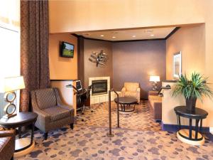 vestíbulo con sala de espera con sillas y TV en Crystal Inn Hotel & Suites - Midvalley, en Murray