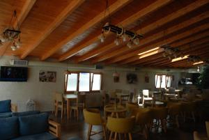 a restaurant with wooden ceilings and tables and chairs at Olive Tree in Sarandë