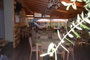 a dining room with a table and chairs and tables and tablesktop at Olive Tree in Sarandë