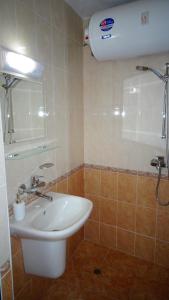 ein Badezimmer mit einem weißen Waschbecken und einer Dusche in der Unterkunft Apartament Bogoridi in Burgas City + 26 Fotos