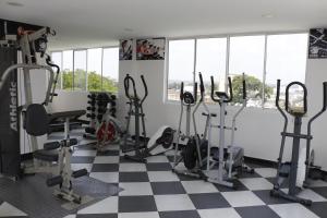 einen Fitnessraum mit mehreren Laufbändern und Heimtrainern in der Unterkunft Hotel Bachue in Barrancabermeja