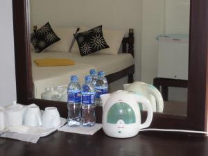 een tafel met flessen water en een spiegel bij Jungle Holiday Home in Hikkaduwa