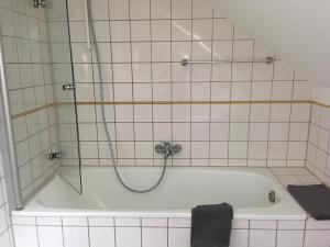 eine Badewanne mit Dusche im Bad in der Unterkunft Gästehaus Villa Lina in Bad Herrenalb