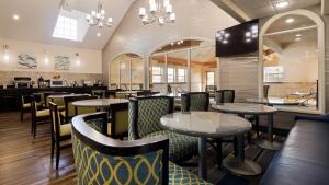 ein Restaurant mit Tischen und Stühlen und eine Bar in der Unterkunft Best Western PLUS Tulsa Inn & Suites in Tulsa
