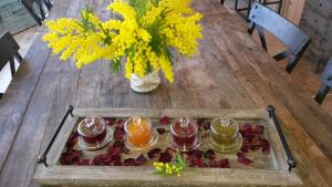 - une table en bois avec un plateau de boissons et de fleurs dans l'établissement Le Clos Des Cambres, aux Arcs-sur-Argens