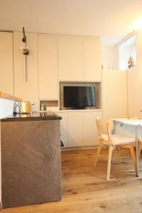 uma cozinha e sala de jantar com uma mesa e uma televisão em Monolocale Monterosa em Champoluc