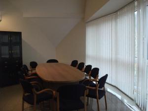 una sala de conferencias con mesa de madera y sillas en Hotel Rittinger, en Bonyhád