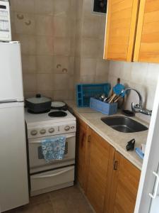 a kitchen with a white stove and a sink at Edificio Club del Mar in Punta del Este +7 photos
