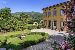 a large yellow house with a garden in front of it at Coselli's luxury Villas in Capannori