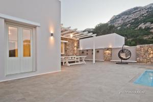 a white house with a swimming pool and a patio at Lux View Villas in Kyra Panagia