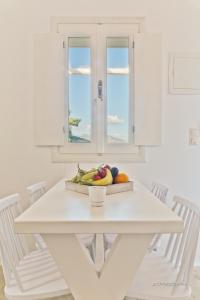 a white table with a bowl of fruit on it at Lux View Villas in Kyra Panagia