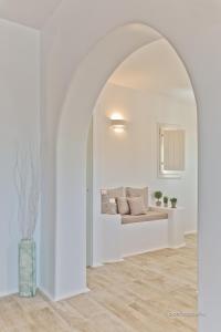 a white living room with a couch in an archway at Lux View Villas in Kyra Panagia