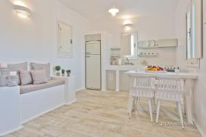 a white kitchen with a table and chairs in it at Lux View Villas in Kyra Panagia