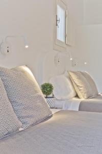 a white bedroom with two beds and a mirror at Lux View Villas in Kyra Panagia