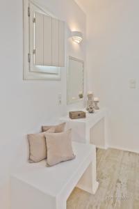 a white living room with a white bench with pillows at Lux View Villas in Kyra Panagia