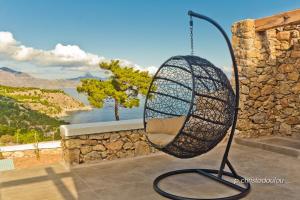 a basket swing hanging from a stone wall at Lux View Villas in Kyra Panagia