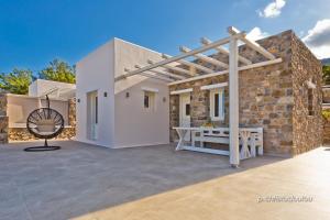 a white house with a wooden pergola on a patio at Lux View Villas in Kyra Panagia
