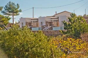 a row of houses with trees in the foreground at Lux View Villas in Kyra Panagia
