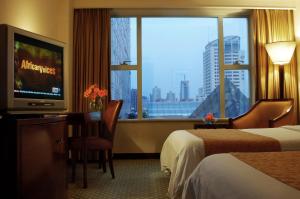 a hotel room with two beds and a tv and a window at Ningbo Portman Plaza Hotel in Ningbo