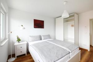 una camera bianca con letto bianco e specchio di Ferienhaus Caputh a Caputh