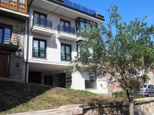a white building with a tree in front of it at Four Rooms in Muxia