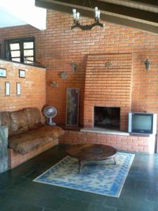 a living room with a couch and a fireplace at Pousada Buganvilia in Bombinhas
