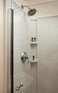 ducha con puerta de cristal y cabezal de ducha en Squam Lake Inn, en Holderness