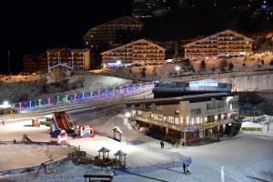 Hotel Laghetto في براتو نيفوسو: مبنى به منحدر التزلج في الثلج ليلا
