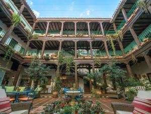 un gran edificio con mesas, sillas y plantas en El Rey Moro Hotel Boutique en Sevilla