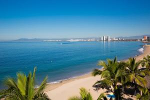a view of a beach with palm trees and the ocean at Hotel El Pescador in Puerto Vallarta