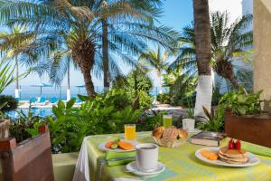 a table with food and a view of the ocean at Hotel El Pescador in Puerto Vallarta +40 photos