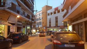 eine Stadtstraße mit auf der Straße geparkt in der Unterkunft City Space Apartments in Giannitsa
