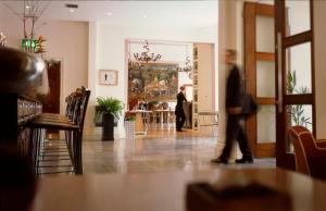 Un homme qui marche dans une pièce avec un tableau sur le mur dans l'établissement The Racquet Club, à Liverpool