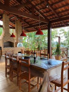 a dining room with a large wooden table and chairs at Chalé Vila Ipê Rolador in Pacoti