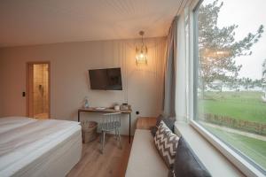 a bedroom with a bed and a large window at Hotel Strandleben in Schleswig