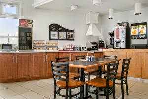 - une table et des chaises dans un fast-food dans l'établissement Days Inn by Wyndham Trois-Rivieres, à Trois-Rivières