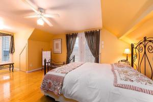 a bedroom with a bed and a ceiling fan at 271 - La Victorienne - Les Immeubles Charlevoix in Baie-Saint-Paul