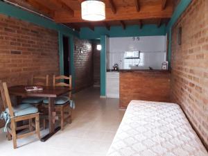 a dining room with a table and a kitchen at Las Encinas in Potrero de los Funes