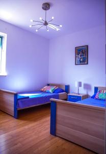 a bedroom with two beds and a ceiling fan at Molo Lozna Apartments in Postira