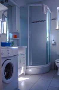 a bathroom with a shower and a washing machine at Molo Lozna Apartments in Postira