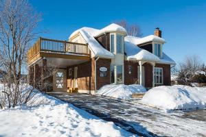 a house is covered in snow at 271 - La Victorienne - Les Immeubles Charlevoix in Baie-Saint-Paul