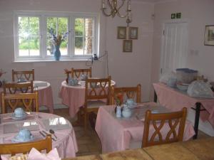 una habitación con mesas y sillas con mantel rosa en The Brambles B&B en Waterbeach