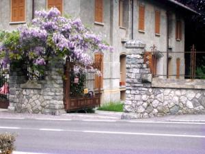 Un edificio con un cancello con fiori viola sopra di Bellagio Ghisallo Penthouse a Bellagio