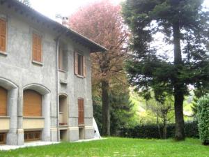 a house with a grass yard next to a building at Bellagio Ghisallo Penthouse in Bellagio