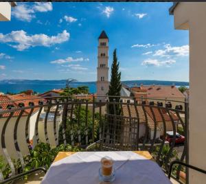 a table on a balcony with a clock tower at Leonarda in Crikvenica