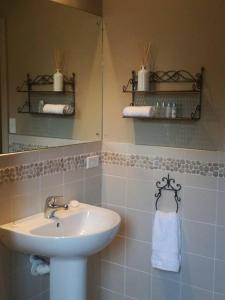 een badkamer met een wastafel en een spiegel bij Conach House in Cambridge