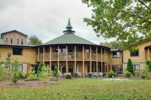 une grande maison en bois avec un toit vert dans l'établissement The Gulliver's Hotel, à Warrington