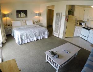 a bedroom with a bed and a table and a kitchen at Capitola Beach Suites in Capitola +13 photos