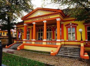 um prédio amarelo com degraus na frente em Guest House Relić em Sombor