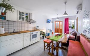 Krnic NEW Fiore في مالي لوسيني: مطبخ وغرفة معيشة مع أريكة وطاولة